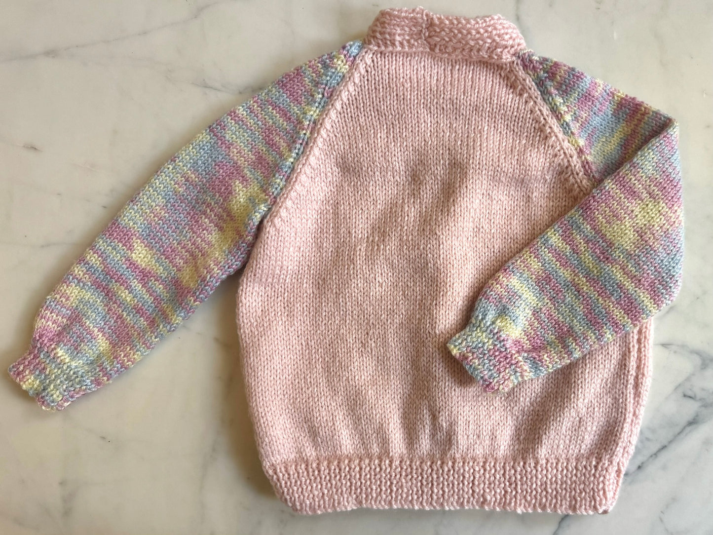 Handknitted Cardigan - 2 years Pastel Pink with Multi Rainbow arms